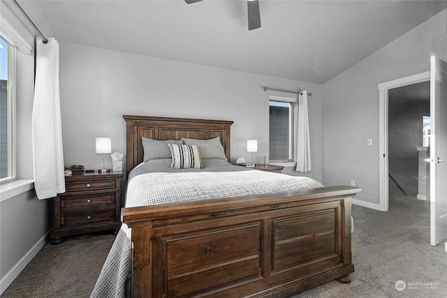 bedroom featuring multiple windows, dark colored carpet, vaulted ceiling, and ceiling fan