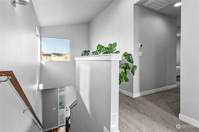 staircase with lofted ceiling and carpet