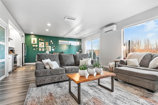 living room featuring a wall mounted air conditioner and hardwood / wood-style floors