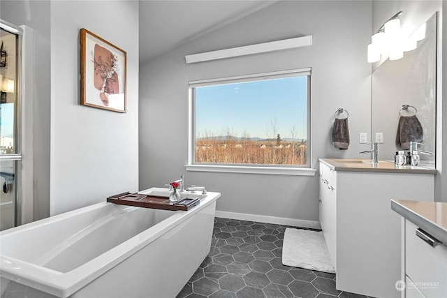 bathroom with tile patterned flooring, vanity, vaulted ceiling, and a tub