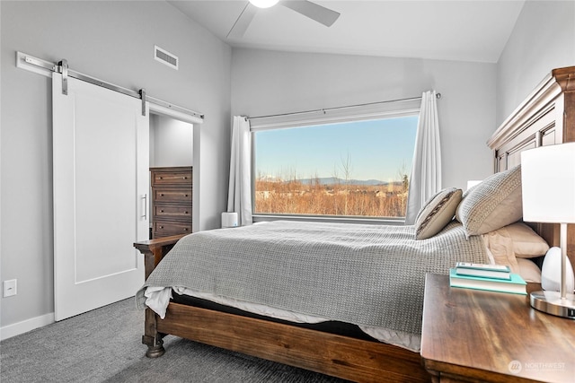 bedroom featuring ceiling fan, a barn door, vaulted ceiling, and carpet