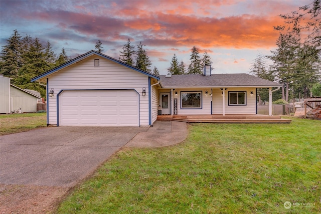 ranch-style house featuring a garage, a yard, and covered porch