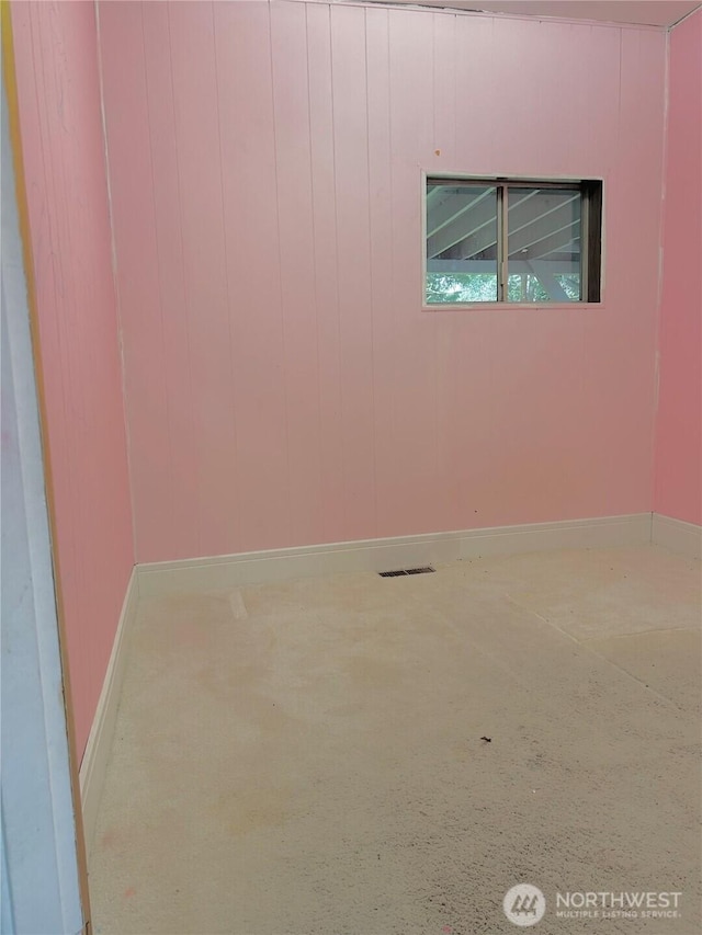 unfurnished room with baseboards