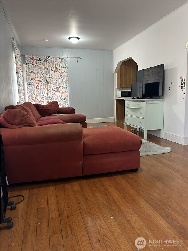 living area with baseboards and wood finished floors