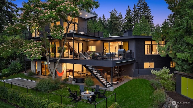 back house at dusk with an outdoor fire pit