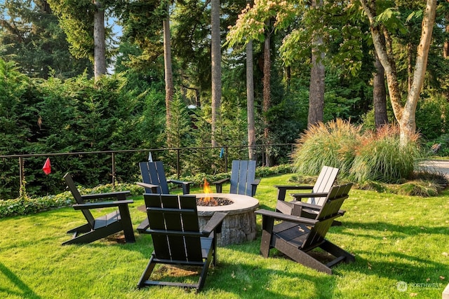 view of home's community with a yard and an outdoor fire pit