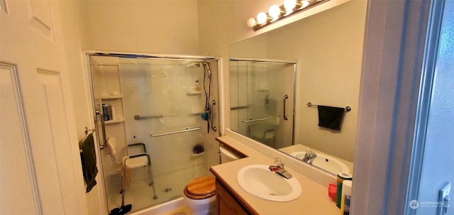 bathroom featuring walk in shower, vanity, and toilet