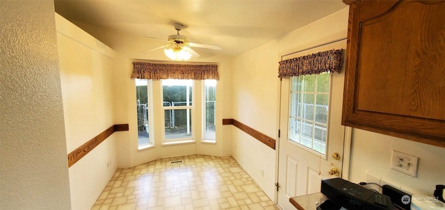 interior space featuring ceiling fan and plenty of natural light