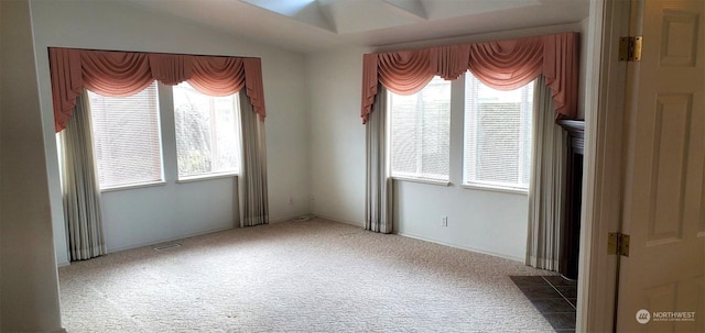 carpeted empty room with vaulted ceiling