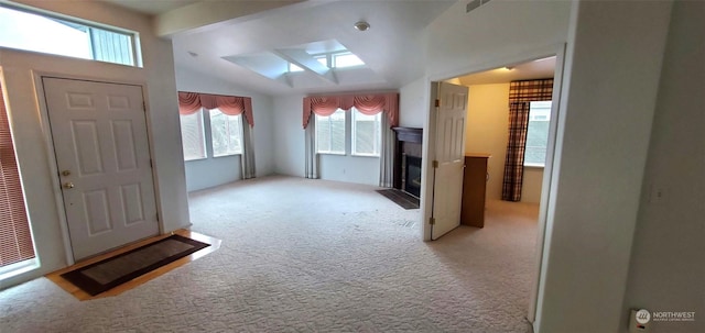 foyer featuring lofted ceiling and light carpet