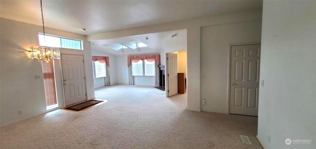 carpeted foyer entrance featuring vaulted ceiling and a notable chandelier