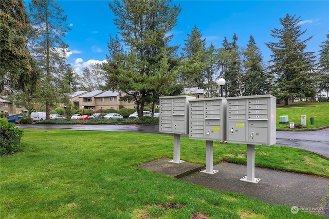 view of property's community featuring a yard and a mail area