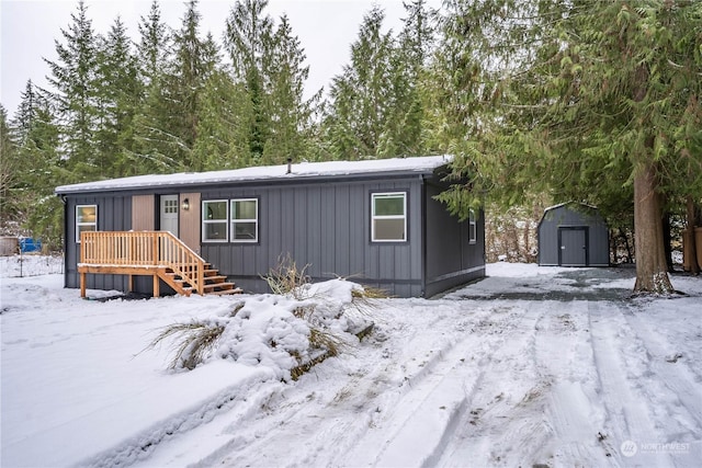 view of front of home with a shed and a deck