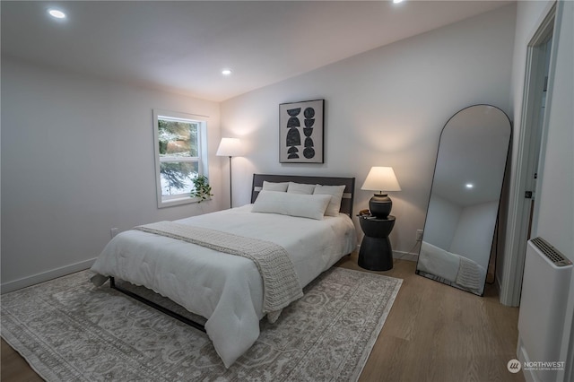 bedroom featuring lofted ceiling and light wood-type flooring