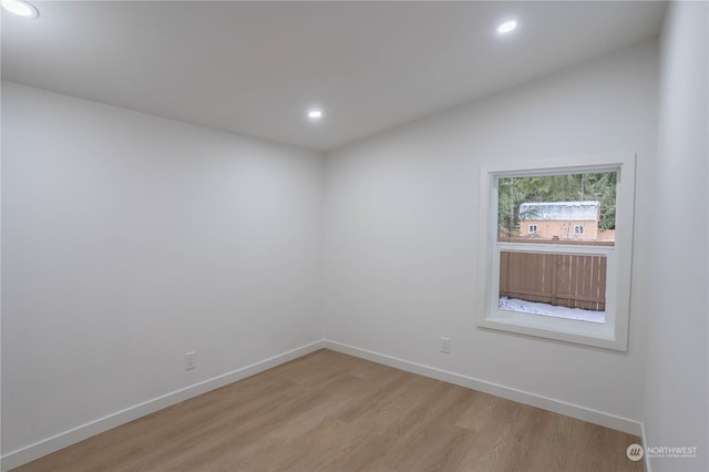 empty room featuring lofted ceiling and light hardwood / wood-style floors