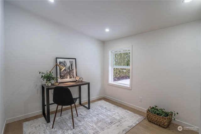 home office with light hardwood / wood-style flooring