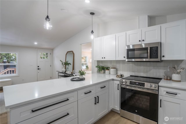 kitchen featuring white cabinetry, appliances with stainless steel finishes, kitchen peninsula, and hanging light fixtures