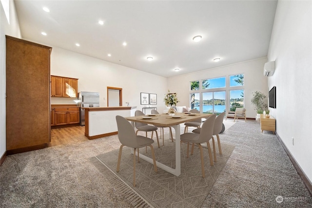 carpeted dining space featuring a wall mounted air conditioner, a towering ceiling, and a water view