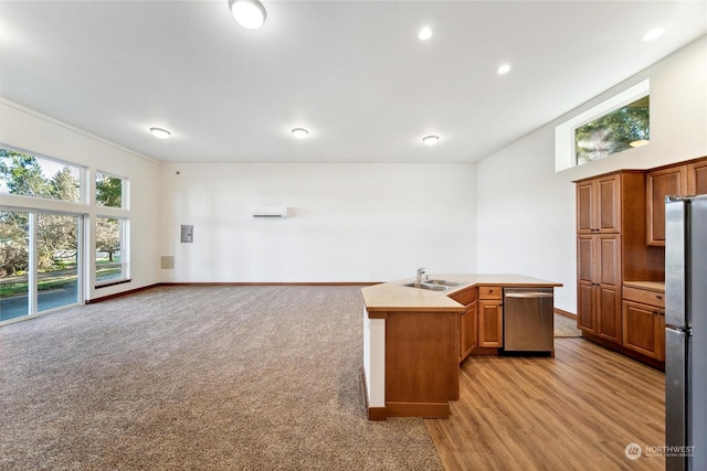 kitchen featuring light colored carpet, appliances with stainless steel finishes, sink, and a center island with sink