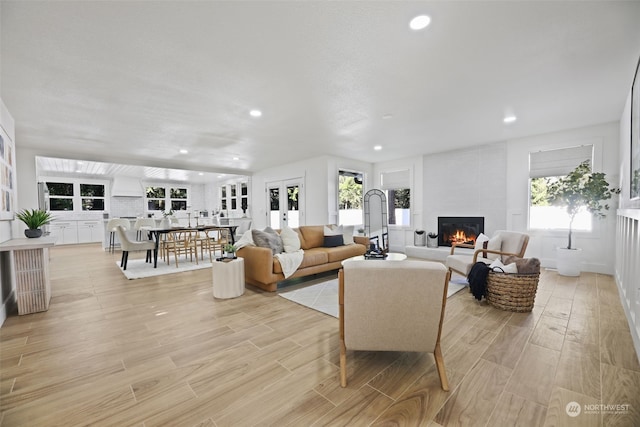 living room featuring french doors, a fireplace, and light hardwood / wood-style floors