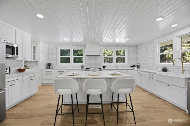 kitchen with stainless steel appliances, white cabinetry, and sink