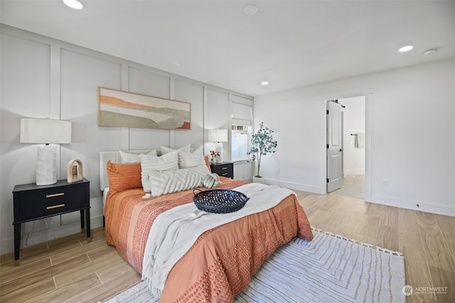 bedroom featuring ensuite bathroom and light hardwood / wood-style floors