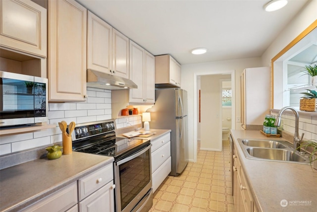 kitchen with stainless steel appliances, sink, and decorative backsplash