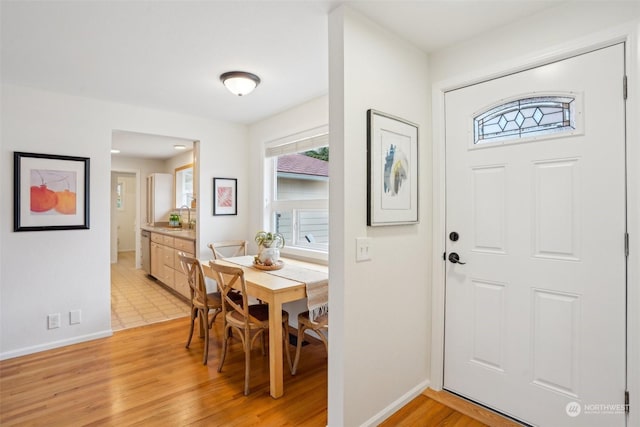 entryway with light hardwood / wood-style floors and sink