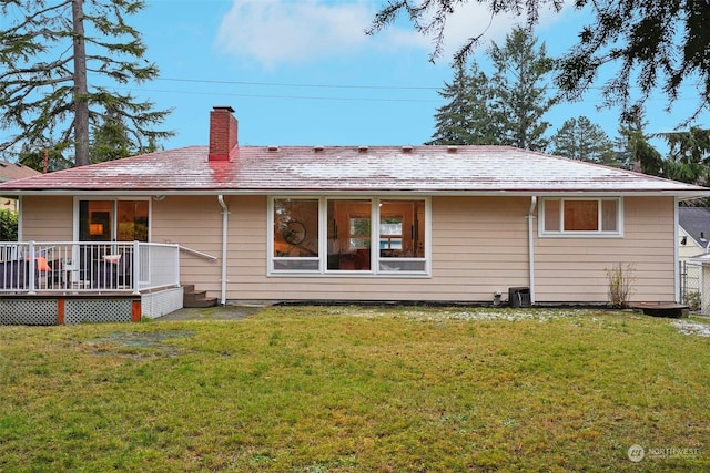 back of house with a wooden deck and a lawn