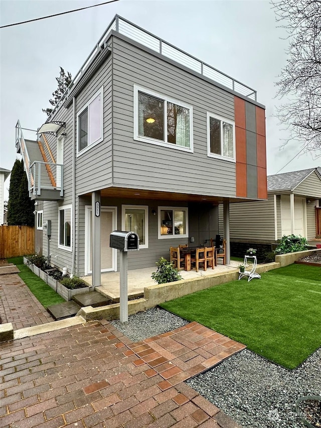 back of house with a yard and a patio