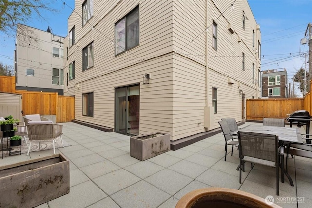 view of patio featuring a grill, fence, and outdoor dining area