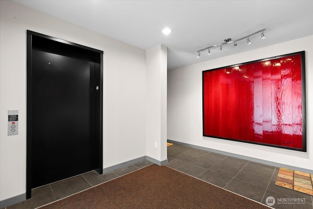 carpeted spare room with baseboards, recessed lighting, tile patterned flooring, and elevator