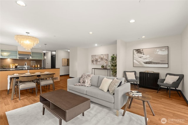 living area with visible vents, an inviting chandelier, light wood-style flooring, and recessed lighting