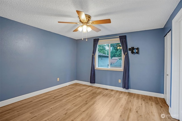 unfurnished room with a textured ceiling, ceiling fan, and light hardwood / wood-style flooring