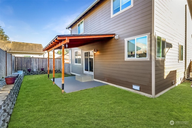 back of house featuring a lawn and a patio area