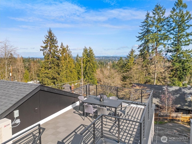 deck featuring a wooded view and outdoor dining space