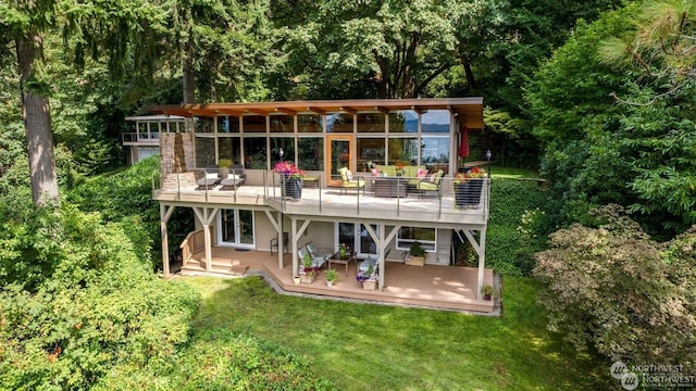 rear view of property featuring a deck and a lawn