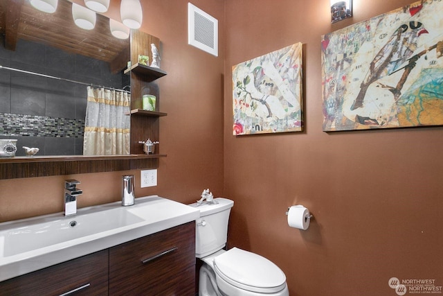 bathroom featuring vanity, toilet, and curtained shower