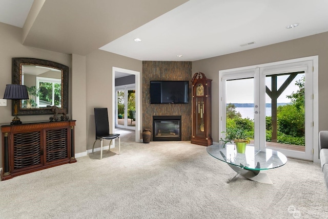 carpeted living room featuring a fireplace and french doors