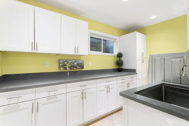 kitchen featuring sink, white cabinets, and light tile patterned flooring