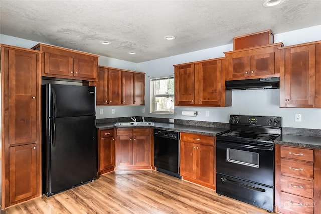 kitchen with light wood-type flooring, sink, a textured ceiling, and black appliances