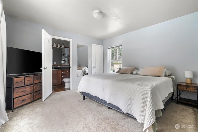 carpeted bedroom featuring ensuite bathroom