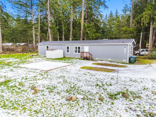 view of snow covered back of property