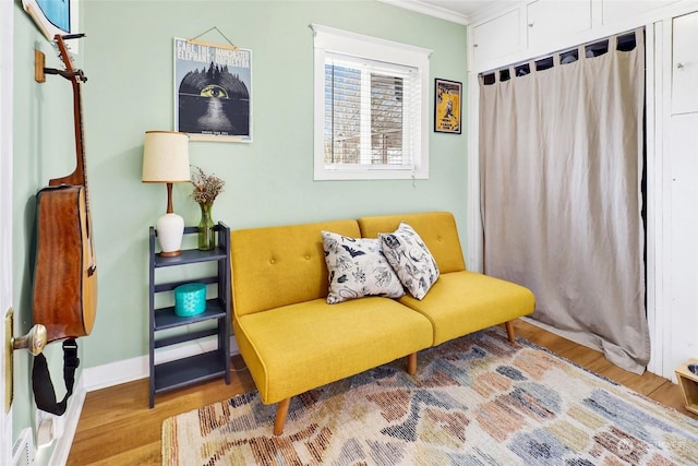 sitting room with crown molding and hardwood / wood-style floors