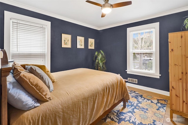 bedroom with ornamental molding, wood-type flooring, and ceiling fan