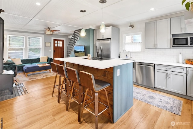 kitchen featuring hanging light fixtures, a breakfast bar area, stainless steel appliances, and a center island