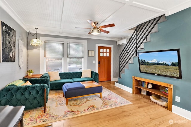 living room featuring hardwood / wood-style flooring, ornamental molding, ceiling fan, and a wall unit AC