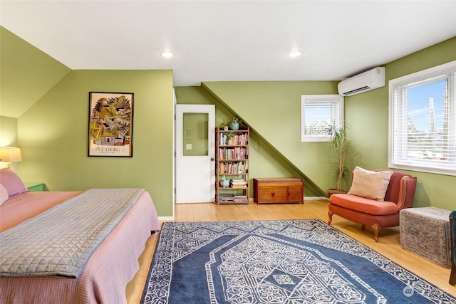 bedroom featuring an AC wall unit and light wood-type flooring