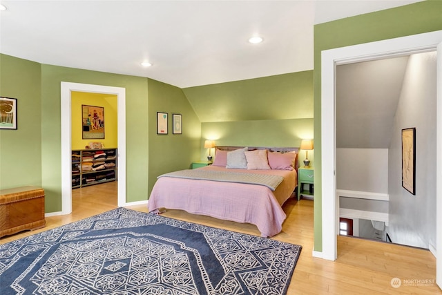 bedroom with wood-type flooring and vaulted ceiling