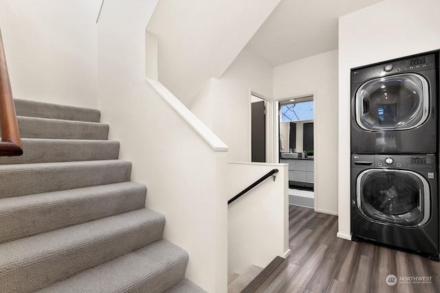 clothes washing area featuring stacked washer / dryer and dark wood-type flooring